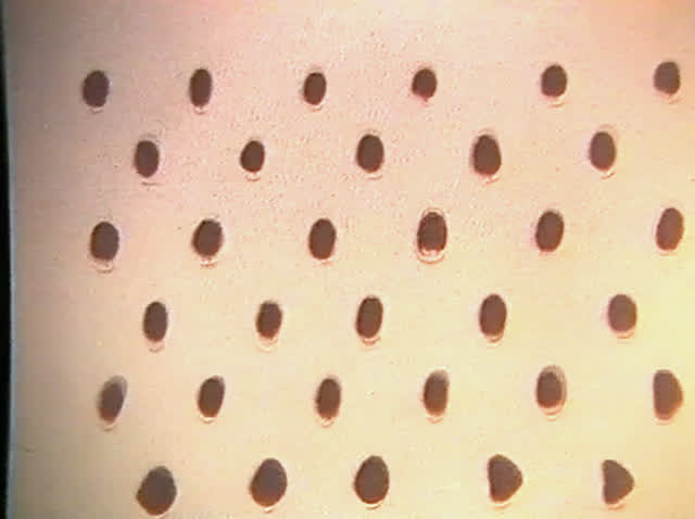 Extreme close-up of a drawn face: one made-up eye, a cheek and the mouth corner.