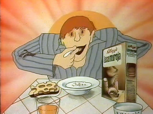 A man in striped pyjamas eats at the breakfast table beside the cereal box.