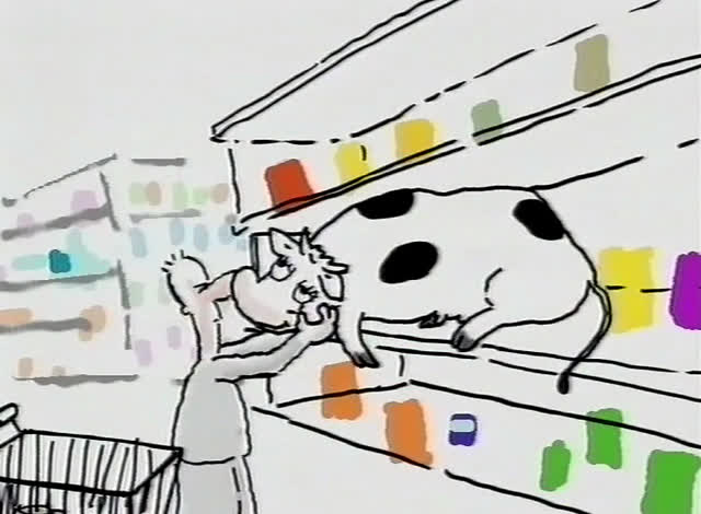 A black and white cow stands on the shelf while the shopper reaches up towards it